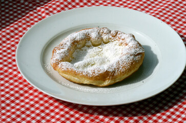 Ausgezogener Krapfen mit Puderzucker
