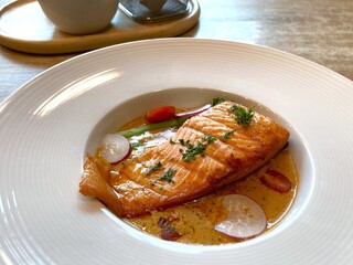 Grilled salmon steak with slice radish and rosemary on wooden table
