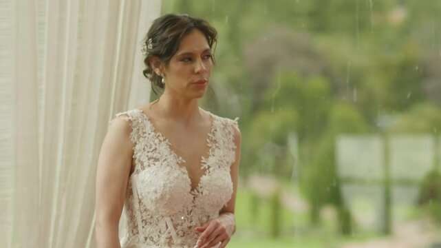 A bride with her back turned, wearing a white dress