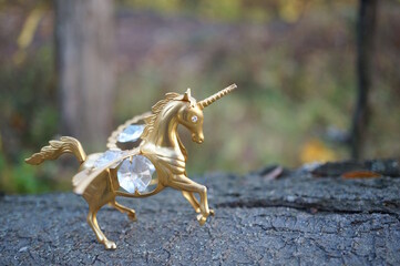 A unicorn figurine with wings decorated with decorative glass.