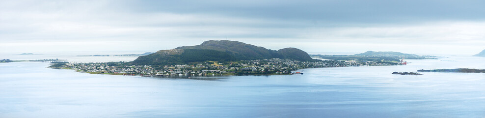 Panoramic view of Giske island next to Alesund on Norway’s west coast on a cloudy day, with lush greenery and calm coastal waters