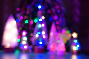 Blurred background. Glowing Christmas trees. New Year's background.