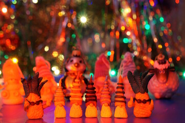 Figures of colorful gnomes and pineapples on the background of Christmas toys. Bright colored background.