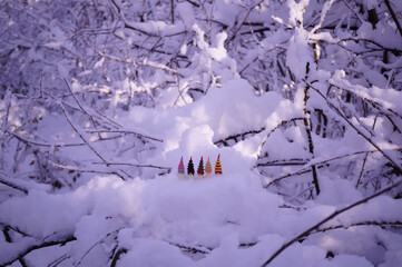 Colorful toy gnomes made of plasticine in the forest against a background of snow. Fabulous scenery.