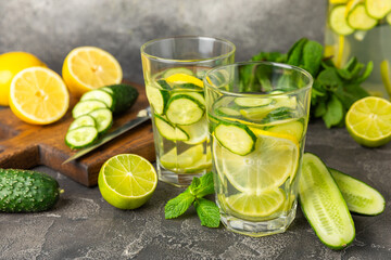 Cucumber water with lemon, lime and mint on a wooden table. Water infused with sliced...