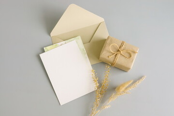 Blank paper card mockup, envelopes and gift box top view on grey blue background. Copy space.Greeting card, holiday , birthday, business, invitation.