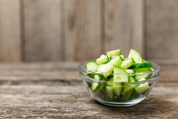 Cucumber on wooden background. Slice of cucumber on background. Fresh organic green cucumbers gherkin. Vegan. Salad ingredient. Farm vegetables. Cut vegetables with knife. Space for text. Copy space