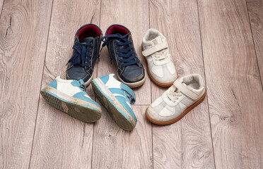 Dirty baby shoes scattered on the floor of the nursery. Decluttering and tidying up
