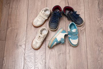 Dirty baby shoes scattered on the floor of the nursery. Decluttering and tidying up