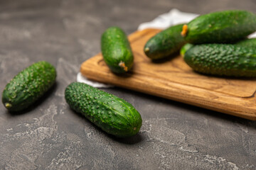 Cucumber on wooden background. Slice of cucumber on background. Fresh organic green cucumbers gherkin. Vegan. Salad ingredient. Farm vegetables. Cut vegetables with knife. Space for text. Copy space
