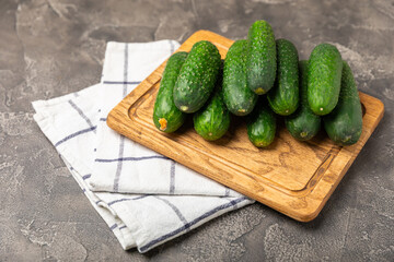 Cucumber on wooden background. Slice of cucumber on background. Fresh organic green cucumbers gherkin. Vegan. Salad ingredient. Farm vegetables. Cut vegetables with knife. Space for text. Copy space
