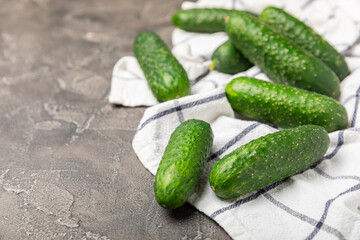 Cucumber on wooden background. Slice of cucumber on background. Fresh organic green cucumbers gherkin. Vegan. Salad ingredient. Farm vegetables. Cut vegetables with knife. Space for text. Copy space