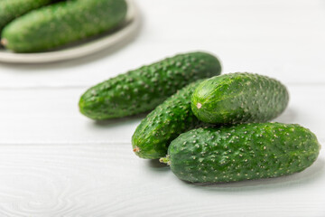 Cucumber on wooden background. Slice of cucumber on background. Fresh organic green cucumbers gherkin. Vegan. Salad ingredient. Farm vegetables. Cut vegetables with knife. Space for text. Copy space