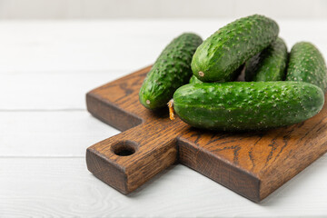 Cucumber on wooden background. Slice of cucumber on background. Fresh organic green cucumbers gherkin. Vegan. Salad ingredient. Farm vegetables. Cut vegetables with knife. Space for text. Copy space