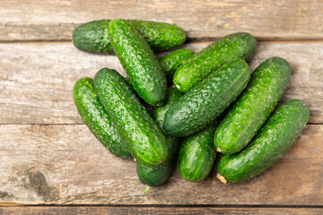 Cucumber on wooden background. Slice of cucumber on background. Fresh organic green cucumbers gherkin. Vegan. Salad ingredient. Farm vegetables. Cut vegetables with knife. Space for text. Copy space