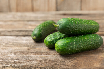 Cucumber on wooden background. Slice of cucumber on background. Fresh organic green cucumbers gherkin. Vegan. Salad ingredient. Farm vegetables. Cut vegetables with knife. Space for text. Copy space
