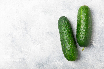 Cucumber on wooden background. Slice of cucumber on background. Fresh organic green cucumbers gherkin. Vegan. Salad ingredient. Farm vegetables. Cut vegetables with knife. Space for text. Copy space