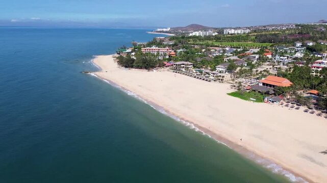 Drone performs a smooth half-circle orbit over Patong Beach, capturing the shoreline, beachfront resorts, and vibrant tropical atmosphere of Phuket, Thailand.