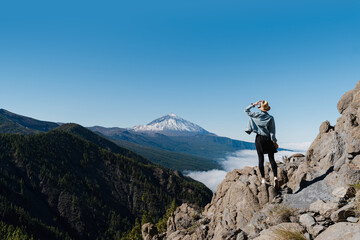 Tourist standing on mountain admiring breathtaking view of volcano Teide, Tenerife, Canary, Spain.