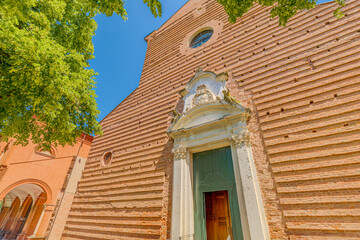 close up of the Saint Christopher church, in Charterhouse in Ferrara city of Italy, with its terracotta bricks facade and bell tower in a sunny day is a beautiful example of Renaissance architecture.