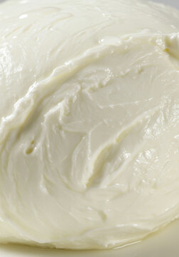 A close up view of a fresh ball of creamy white mozzarella cheese.