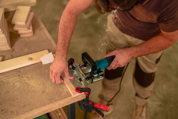 Skilled carpenter uses a biscuit joiner to create a perfect joint in wooden planks, demonstrating...