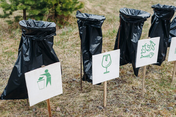 three black trash bags in nature, sorting garbage concept, eco-friendly