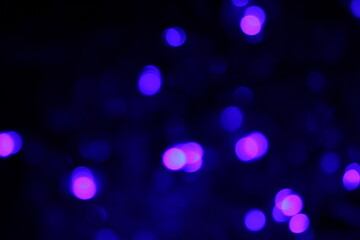 Christmas lights in bokeh. Outside in December. Snow and blue bokeh on a black background, bokeh abstract background, modern technological abstract background. Blue Christmas background, Xmas bokeh 
