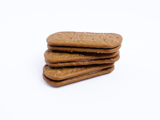 Stack of chocolate cream sandwich biscuits on a white background, sweet and crunchy with visible sugar crystals