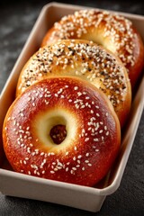 Delicious breakfast bagel on dark plate next to a cup of fresh coffee. On bistro countertop.	
