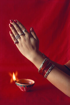Diwali deepawali festival, woman namaskar and diya on red background
