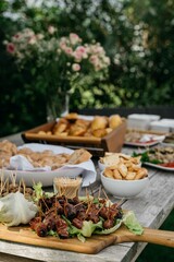 Outdoor table with appetizers in a garden setting.