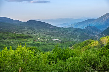 Serene mountain valley with distant villages. A lush green valley stretches between rolling hills and distant mountains. Peaceful and refreshing mountain landscape. Turkey