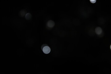 white and fire silver bokeh on a black background, bokeh abstract background, modern technological abstract background. white Christmas background, Xmas backdrop 
