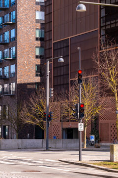 Street view of &Oslash;restad residential district with modern brick buildings, traffic lights, and clear blue sky, ideal for urban design, architecture, and cityscape stock.