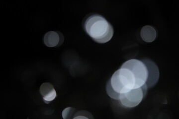 white and fire silver bokeh on a black background, bokeh abstract background, modern technological abstract background. white Christmas background, Xmas backdrop 
