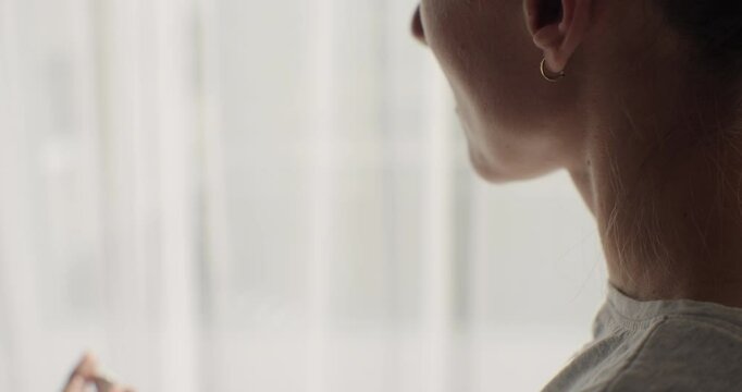 Close-up hands of young woman opening charging case and placing wireless headphones.