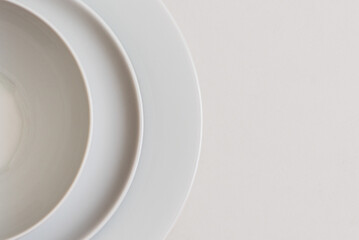 Culinary minimalism: composition of white plates on white background