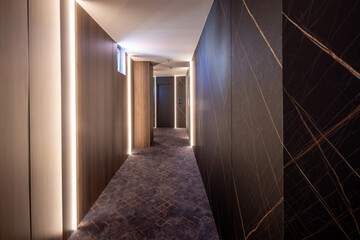 Interior of a long hotel corridor, doorway