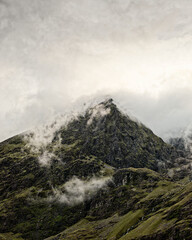 Carrauntoohil, the highest peak in Ireland, looks really impressive in the lush landscape. There are clouds swirling around the top of the mountain, which makes it look really dramatic and grand.