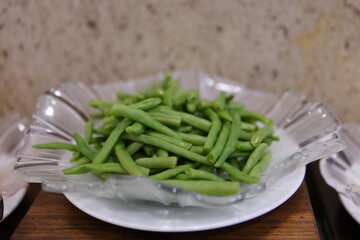 A close-up view of vibrant green beans starting to boil in a steaming pot. Cooking vegetarian and healthy eating concept.