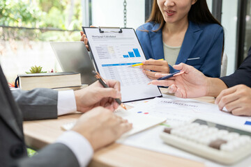 A group of people are working on a project and planning a business plan by sifting through documents and calculating budgets and exchanging information with each other. This scene shows teamwork
