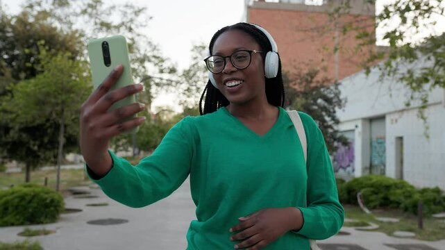 Young African American woman making a video call on smartphone in slow motion