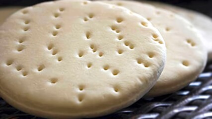 A bakery's fresh petta, a type of bread that resembles a bun, made for consumption.