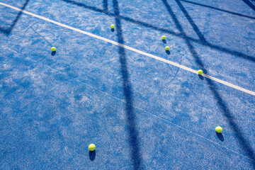 padel balls on a blue artificial grass paddle tennis court - obrazy, fototapety, plakaty