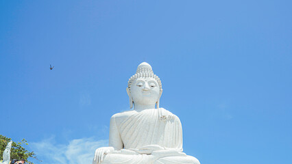 Phuket Big Buddha statue. afternoon light sky and blue ocean are on the back of white Phuket big Buddha is the one of landmarks on Phuket island Thailand.