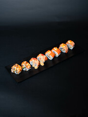 Variety of Premium Salmon Sushi Rolls on Black Serving Plate
