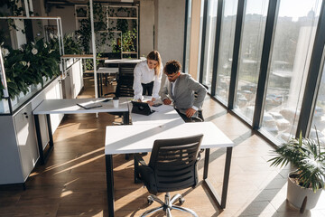 Illuminated by sunlight. Man and woman are indoors in modern building