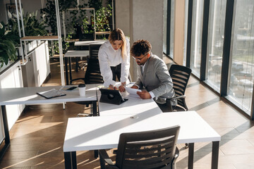 Illuminated by sunlight. Man and woman are indoors in modern building