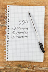 Creating a standard operating procedure with a notebook and pen